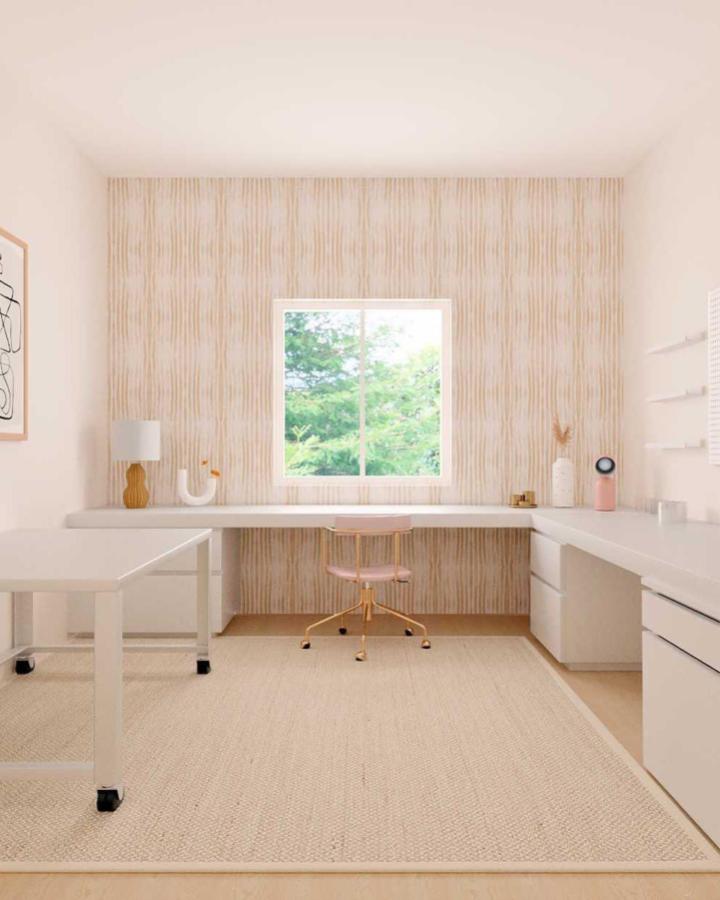 Fluted wood accent wall craft room from @passport2parenthood. White L-shaped desk with pink chair and natural lighting.
