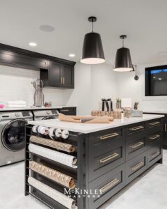 Dark green kitchen island from @mckinleymastersyyc with built-in paper roll storage and brass hardware details.
