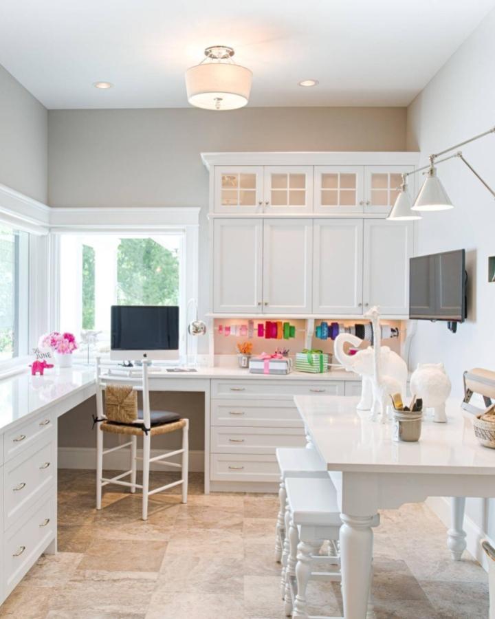 Bright white craft room from @studio_m_interiors featuring floor-to-ceiling storage cabinets and built-in workspace.