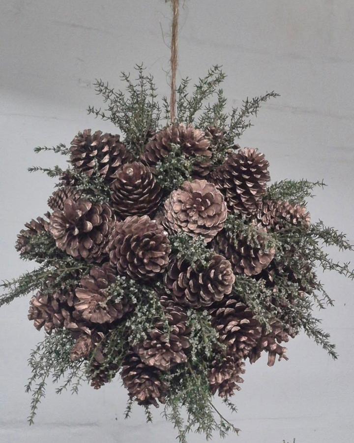Natural pinecone kissing ball from @andrea.topiarycreations featuring frosted greenery, perfect christmas crafts for adults with rustic charm