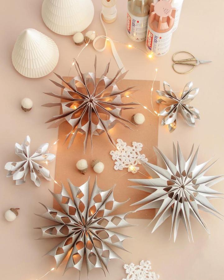Metallic paper snowflakes from @mummy_and_my_three featuring champagne and silver tones with accordion-fold construction