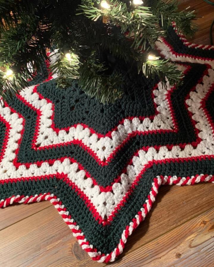 Crochet star-shaped tree skirt from @bettymcknit featuring green, white, and red striped pattern with twisted edging.