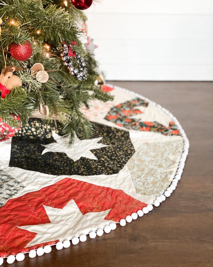 Quilted star patterned tree skirt from @brittanytunison with pom-pom trim and mixed fabric prints