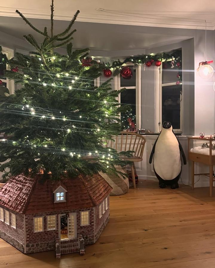 Miniature brick cottage structure from @80erbarn wrapping tree base with illuminated windows and textured roof