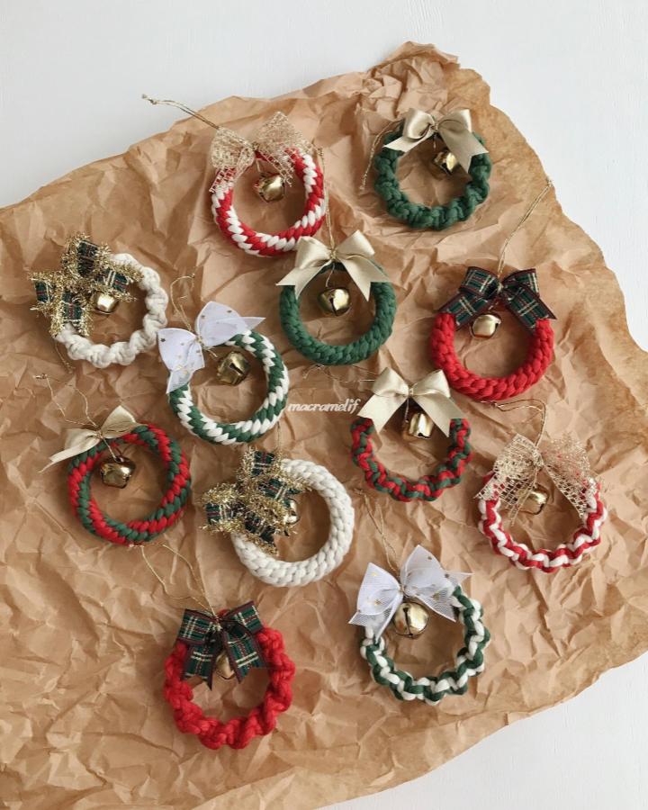 Festive mini wreath ornaments from @macramelif. Yarn, bows, bells, and plaid ribbons create texture.