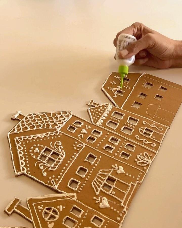 Gingerbread house pieces from @skygoodiesco with white icing details arranged flat before assembly into village structure