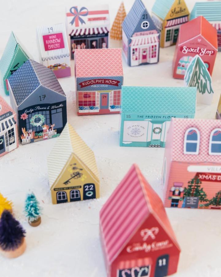 Colorful paper advent house village from @leo.and.blossom with patterned roofs and festive shop signs.