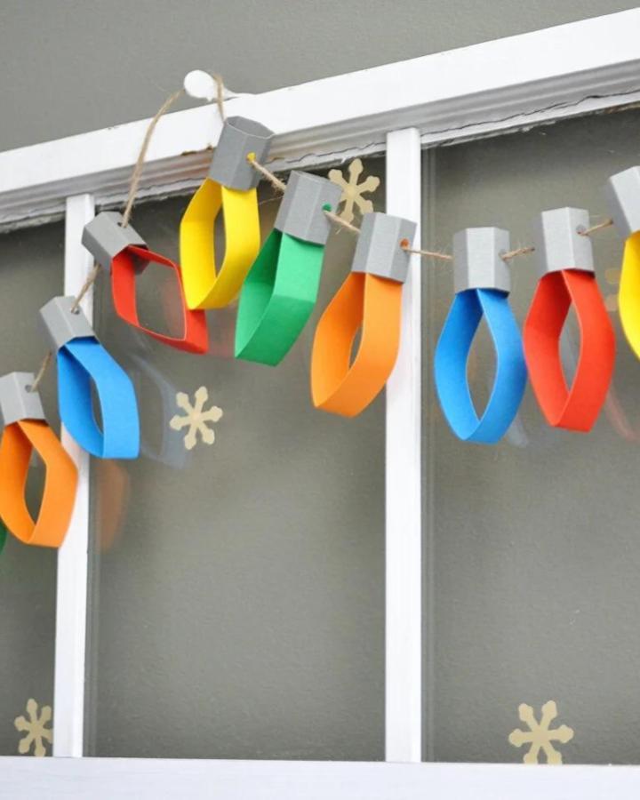 Colorful looped paper light bulb garland from Stubbornly Crafty. Twine strung with vibrant bulbs and stars.