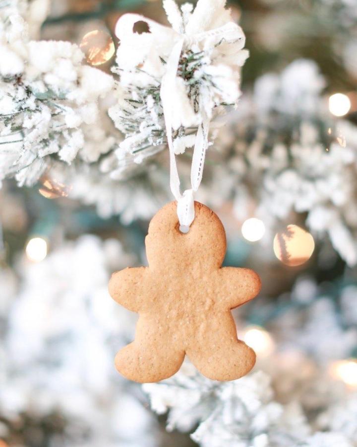 Plain gingerbread christmas tree ornaments from @fraicheliving hanging on a white flocked tree with ribbon loops.
