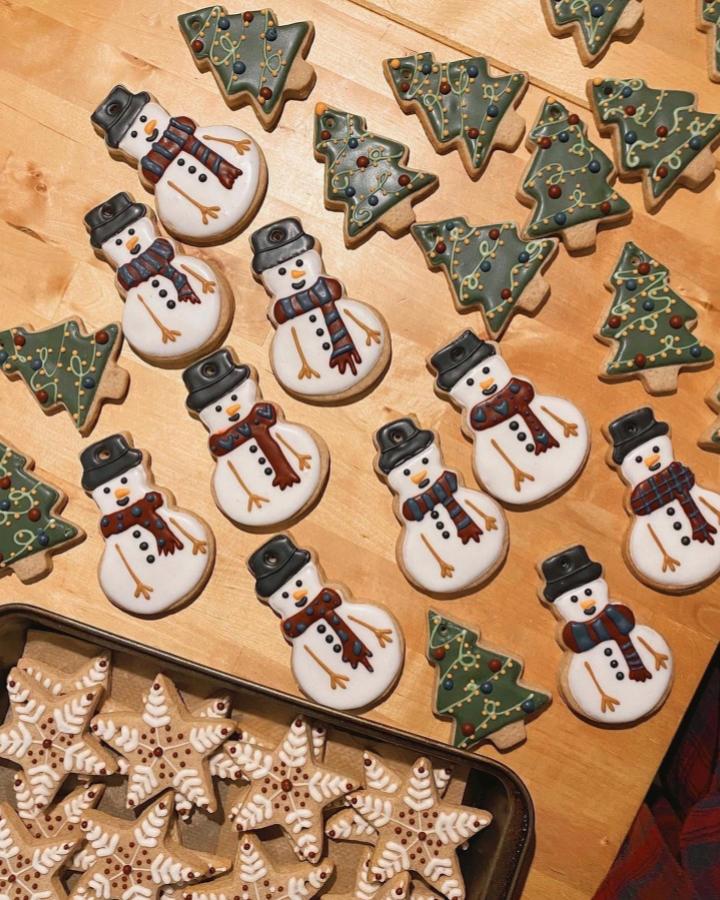 Decorated gingerbread christmas tree ornaments from @ukpastrychefs featuring snowmen and trees with gold garland details
