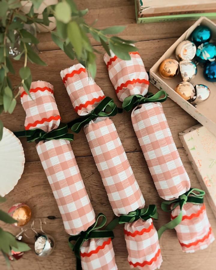 Coral gingham no-sew fabric crackers from @becki_clark_ with green ribbon and chocolate filling on wooden table.
