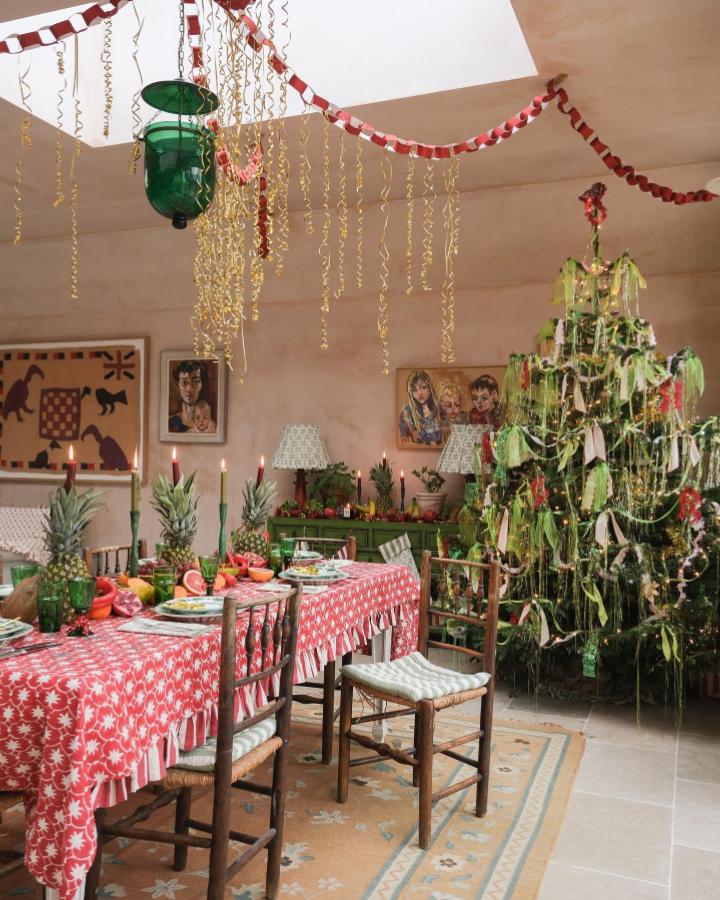 Festive red and white paper chain garlands from @alicepalmerco hanging above craft party table with bold decor.