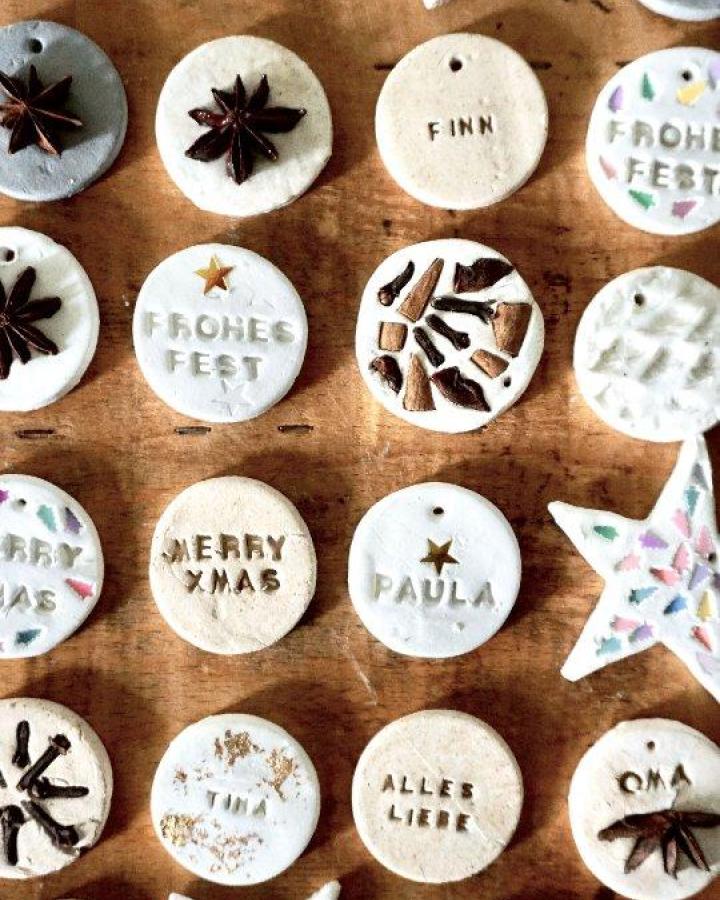 Personalized clay ornaments from @miom_studio with star anise and stamped holiday messages.