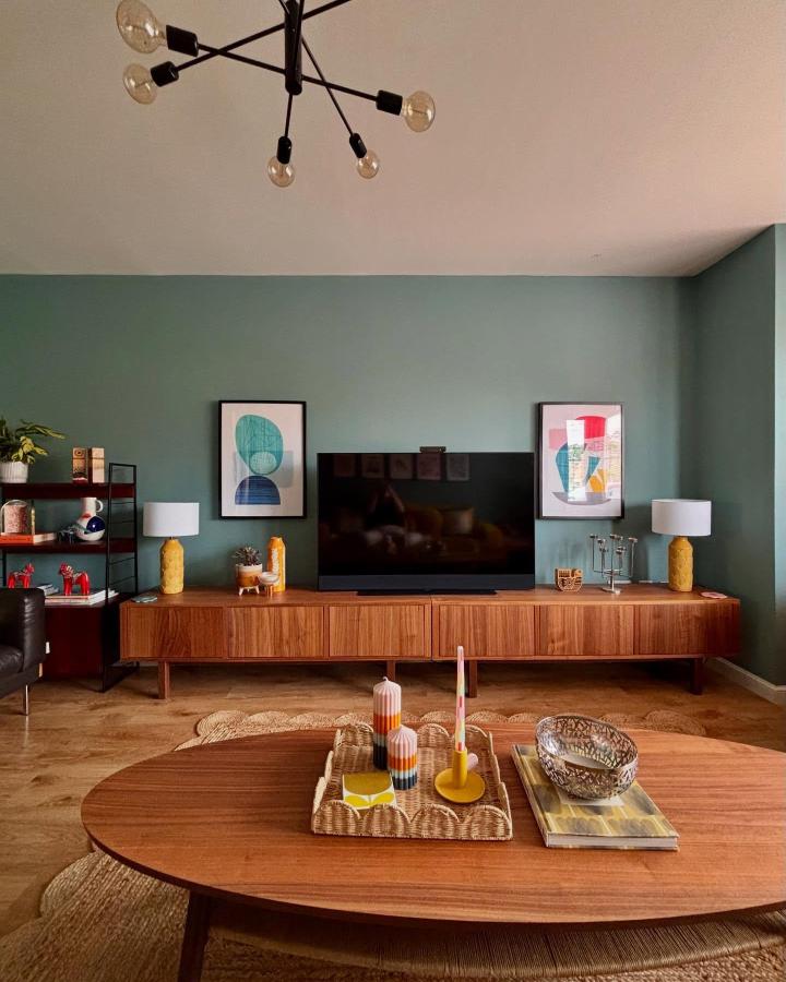 Sage green living room showcasing ikea media center hacks & ideas from @fromcity2suburb. Walnut Stockholm console with retro decor.