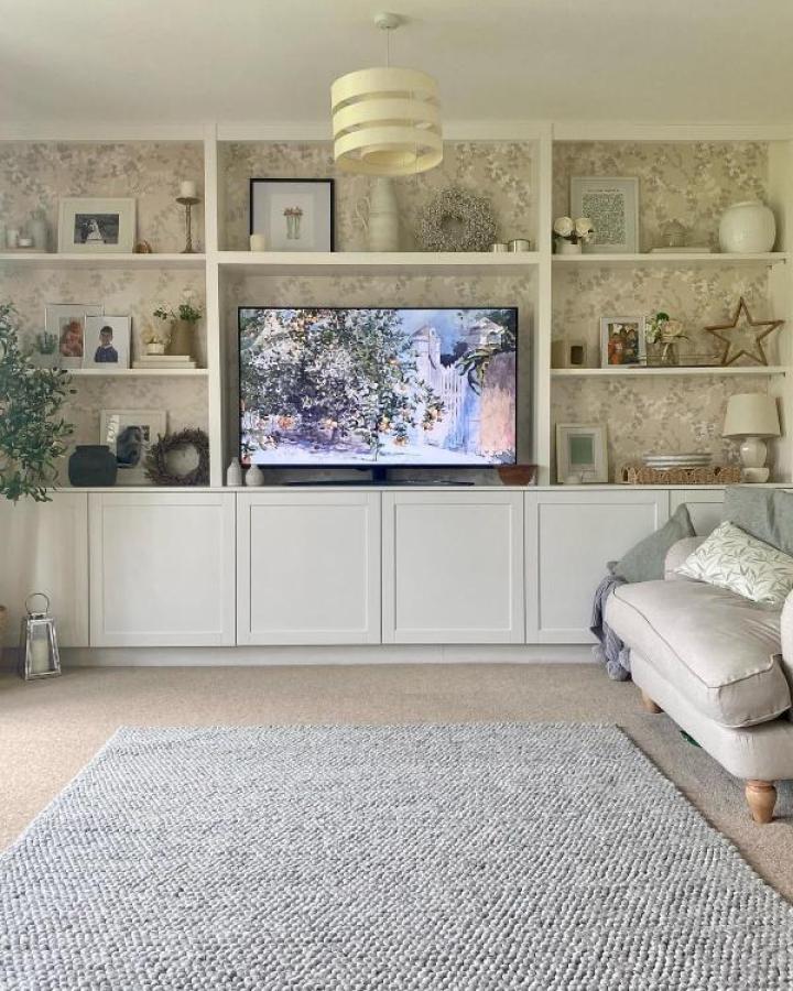 White Besta media unit with floral wallpaper backing from @townhouse_on_the_green. TV centered between styled shelving.