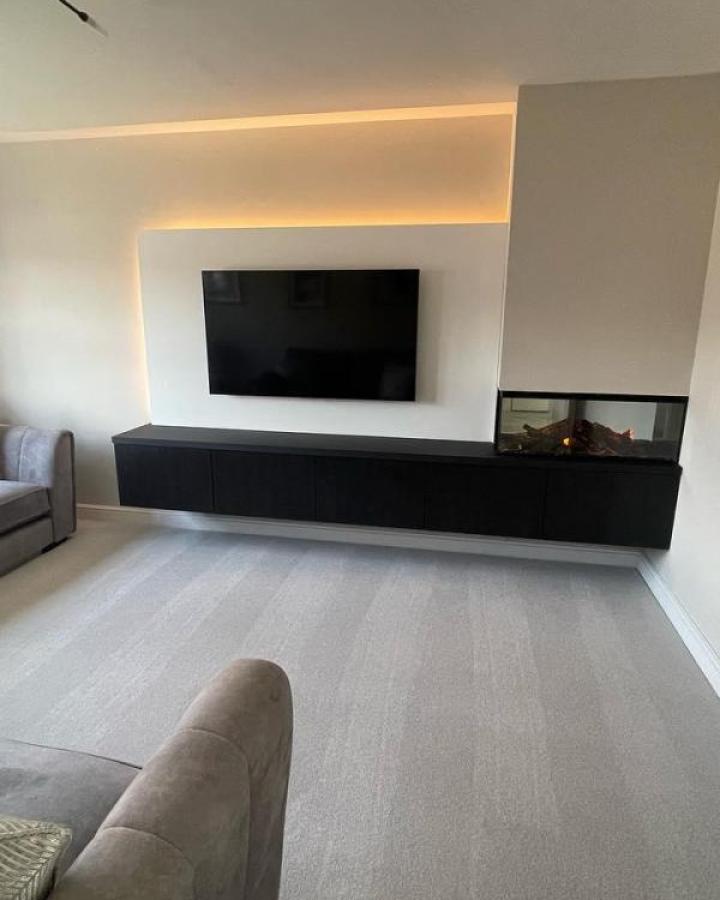 Floating black Besta media unit from @harrison.storyhomes with recessed lighting and modern fireplace insert