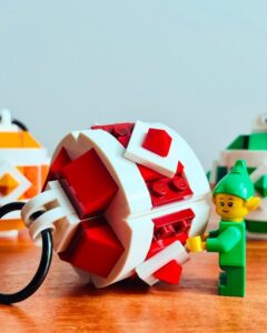 Red and white buildable ornament display from @the.modmom with geometric ribbon pattern and elf figure