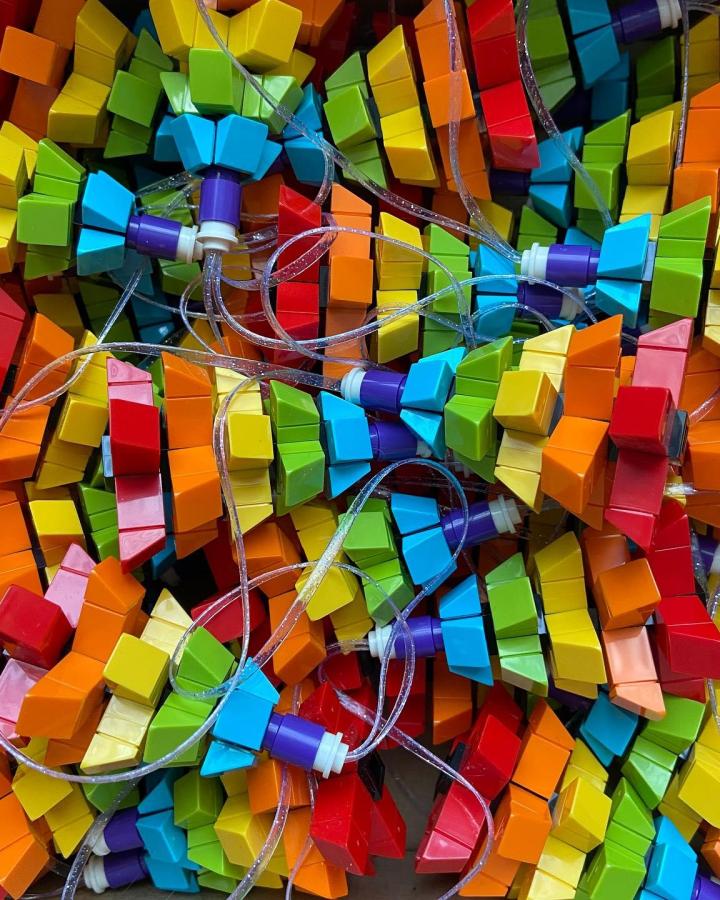 Multicolored brick string lights from @heathersbricks with rainbow slopes threaded on clear wire creating vibrant holiday garland