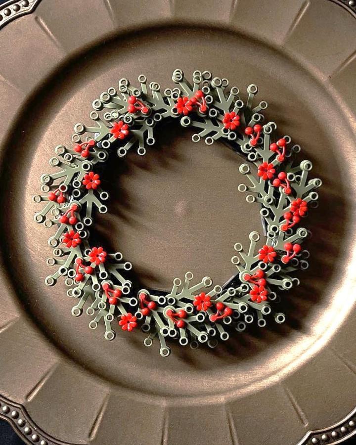 Dark gray and red lego christmas decorations wreath from Rebrickable with scattered floral accents and minimalist botanical styling.