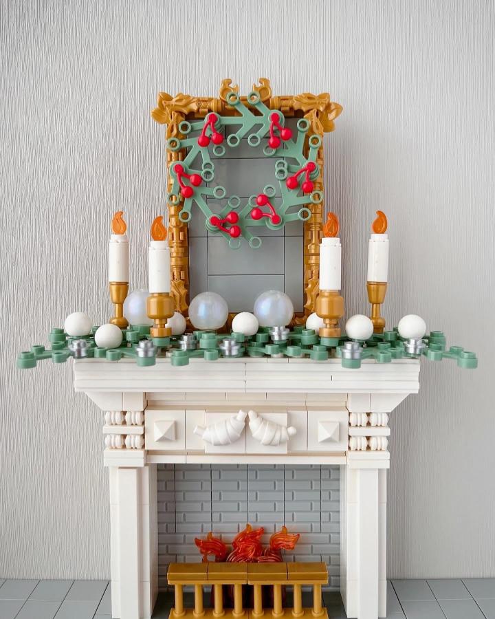 Cream and gold brick fireplace mantel from @umemaruko7 with candlesticks and festive wreath above