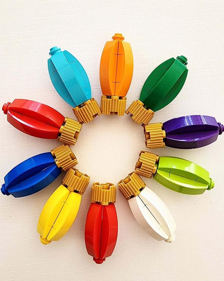 Rainbow vintage bulb wreath from @primitivelegobuilder with golden threaded bases arranged in festive circle.