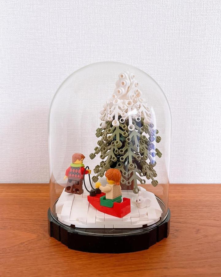 Glass dome display case from @umemaruko7 with gradient tree and minifigures on snowy base