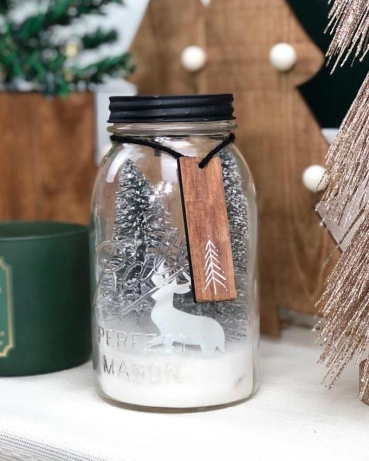 Miniature winter scene jar from @masparkle_diys. Features bottle brush trees and reindeer silhouette on snowy base.