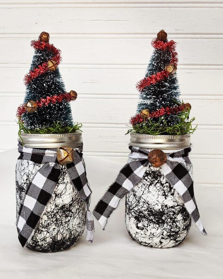 Buffalo check fabric wrapped mason jar christmas crafts from @apronstringsowllady with bottle brush trees and jingle bells.