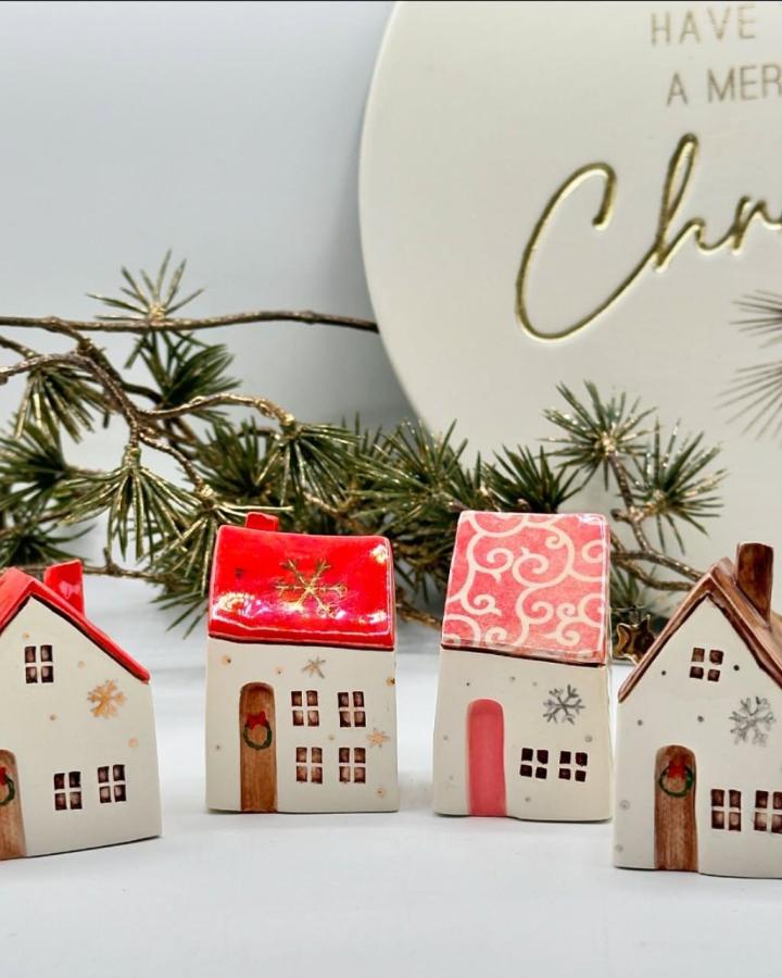Ceramic village houses from @littleclayhouse4 with red roofs and hand-painted holiday details on white surface.