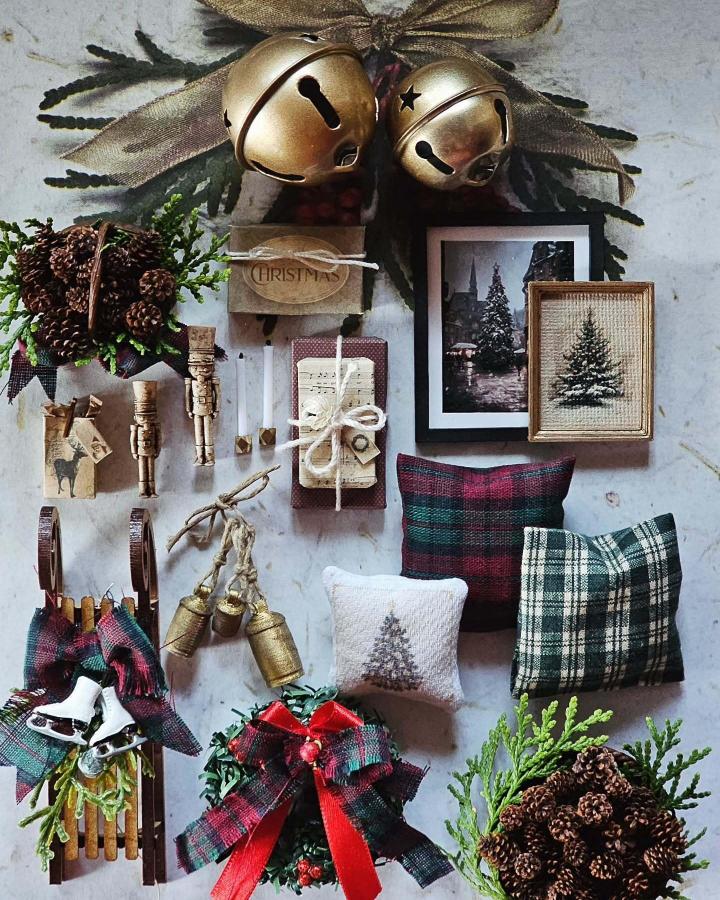 Golden jingle bells with green sprigs and plaid accents from @downsizingminiatures. Includes framed tree art and festive pillows.