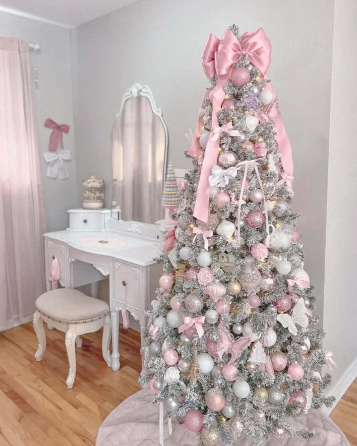Soft pink christmas tree ideas from @editionvicki with oversized satin bow and elegant ornaments in bedroom corner