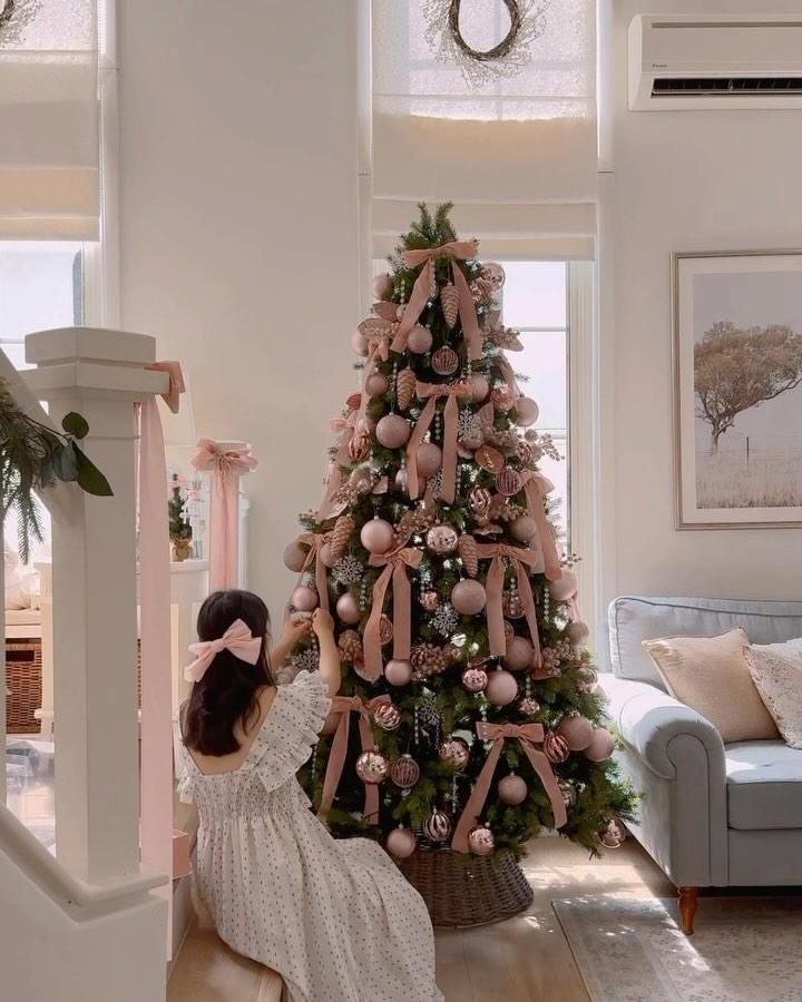 Dusty rose ribbon-draped tree from @cherrydreamy with matte ornaments and woven basket base.