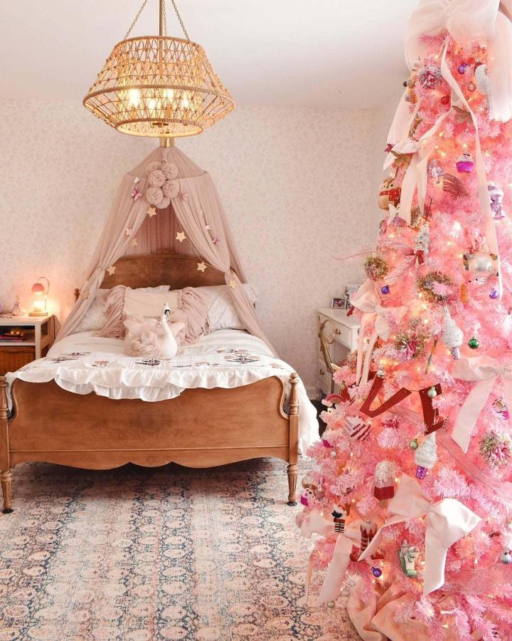 Flocked pink Christmas tree from @a.moroccanspinkandgold.dream in vintage-styled bedroom with canopy bed and woven lighting