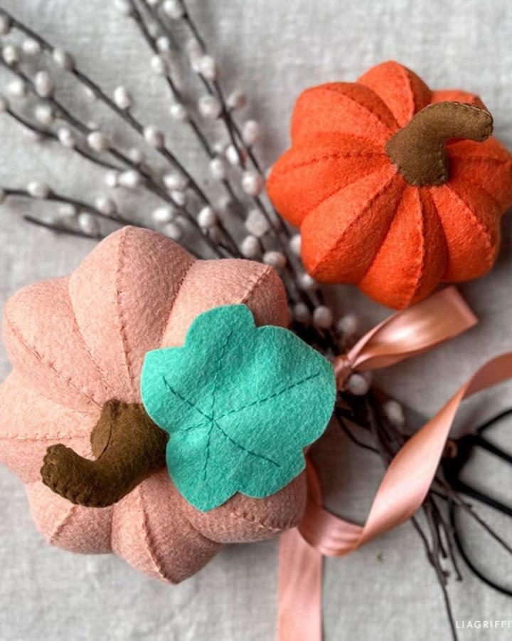 Felt pumpkin crafts for thanksgiving from @liagriffith featuring orange, pink, and turquoise decorative pieces with stitched details