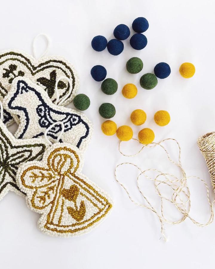 Cream and navy textured ornaments with felt ball accents from @themidnightcreative featuring bell and dove motifs