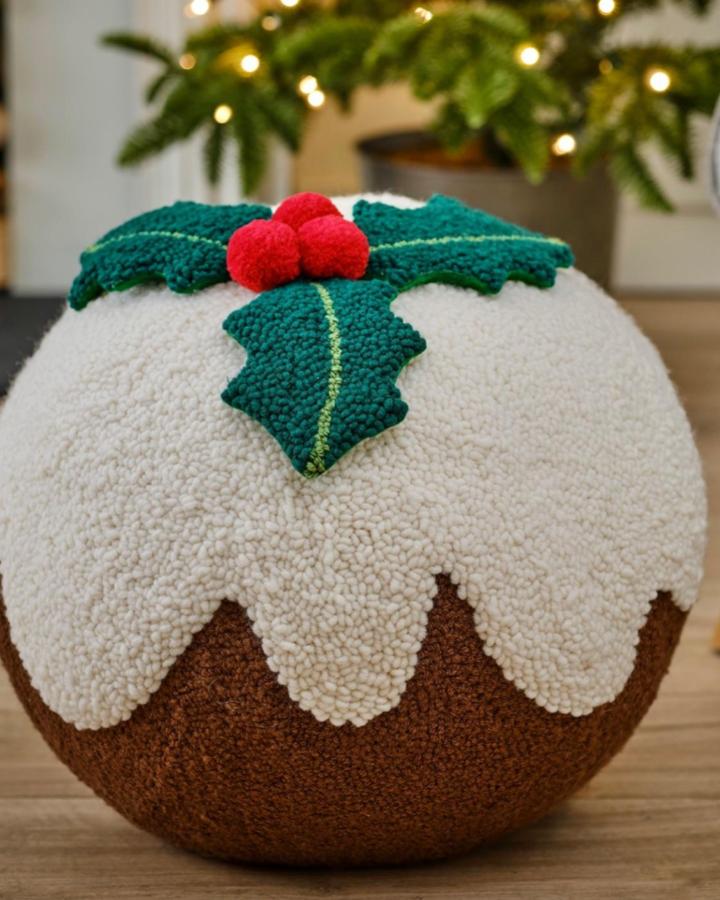 Textured Christmas pudding punch needle christmas decorations from @carolinejanecreative. Round cushion with cream icing and teal holly leaves.