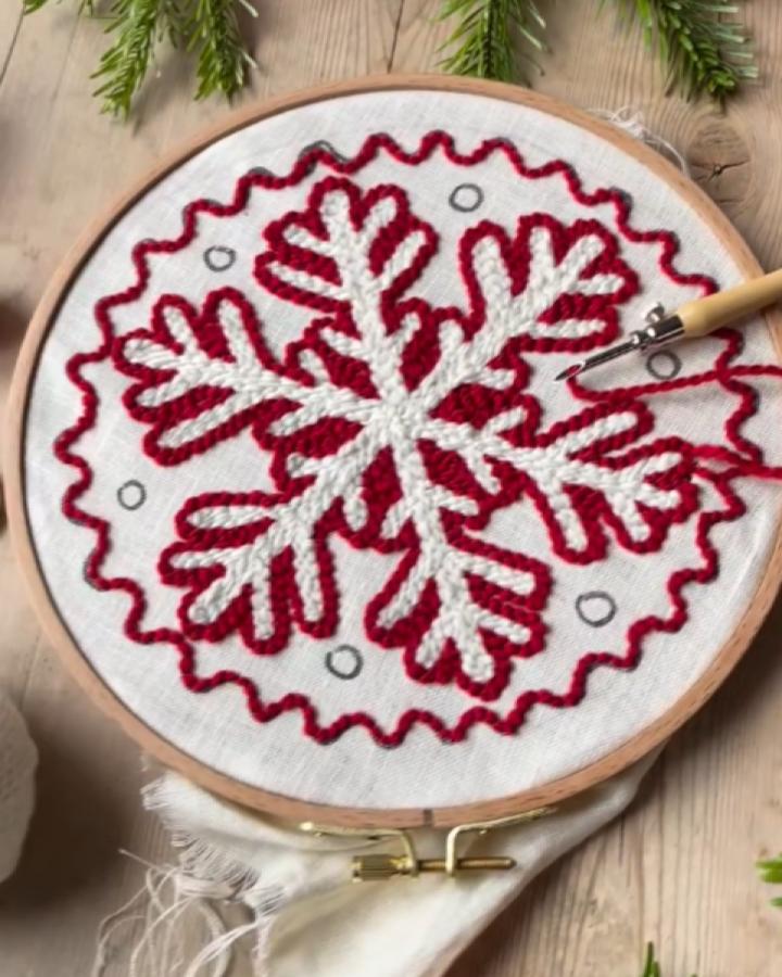 Geometric snowflake hoop art from @toft_uk featuring burgundy and cream yarn with zigzag border detail.