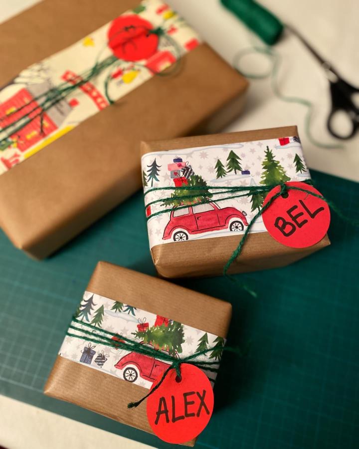 Brown paper christmas wrapping ideas from @hecho_en_casa_a_mano featuring illustrated car bands and red name tags with green twine.