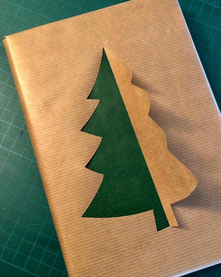 Tan kraft paper with cutout tree design from @hecho_en_casa_a_mano revealing deep green layer beneath