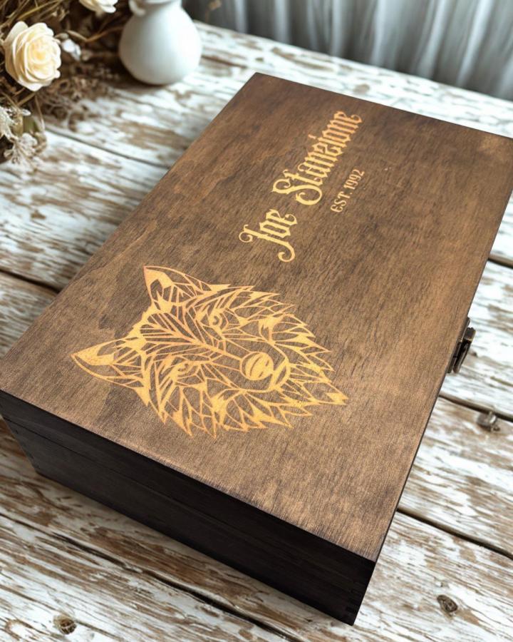 Engraved walnut gift box from @the.tinkers.wagon featuring wolf design and personalized text on wooden surface.