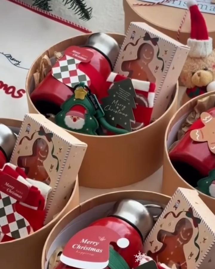 Kraft round gift boxes from @lovewisdshop filled with ornament tins and gingerbread cookie packets.