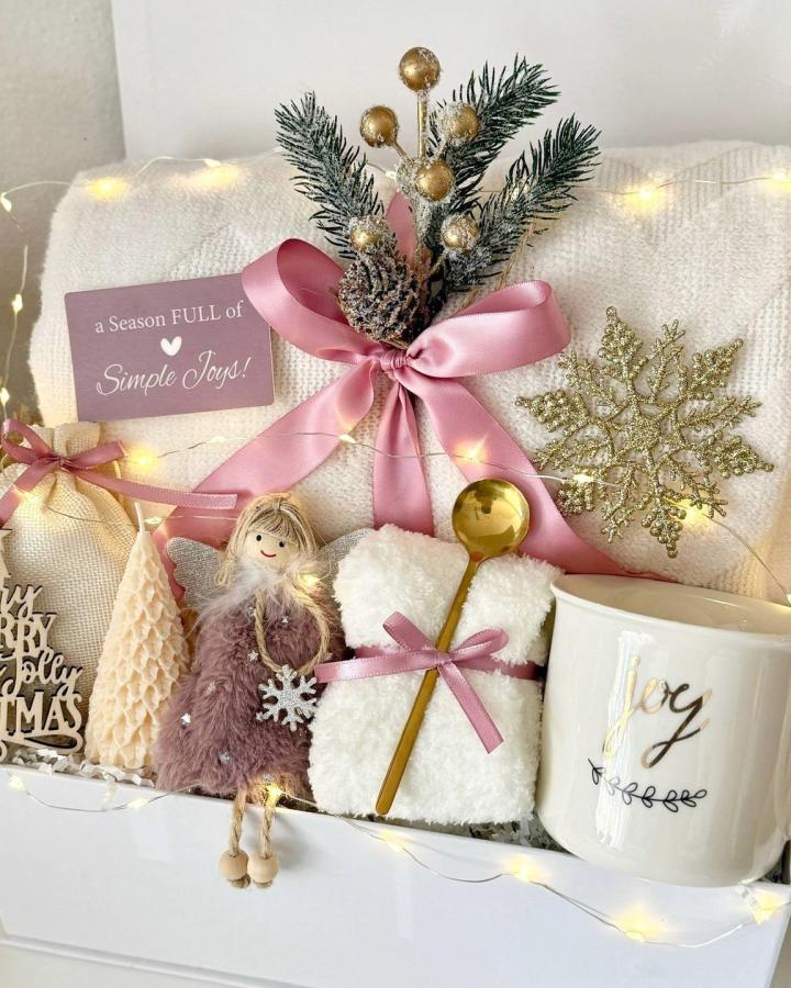 Cream textured gift box from @cuteboxesboutique with dusty rose ribbon and frosted pinecone arrangement.
