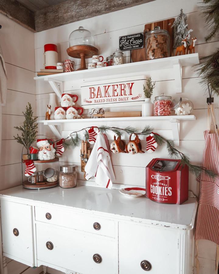 Farmhouse open shelving christmas hot cocoa bar ideas from @ashleyhuze with red accents and festive garland.