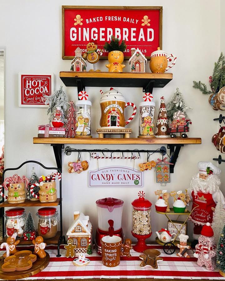 Gingerbread-themed display from @allthingscute_and_coffee featuring vintage red signage and tiered wooden shelving with festive decor.