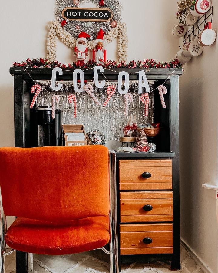 Black desk with tinsel backdrop and candy canes from @shakorialuhmay for festive cocoa display
