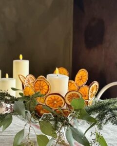 Festive centerpiece featuring diy dried orange christmas decorations from @solis_bohemian with white candles and evergreen sprigs