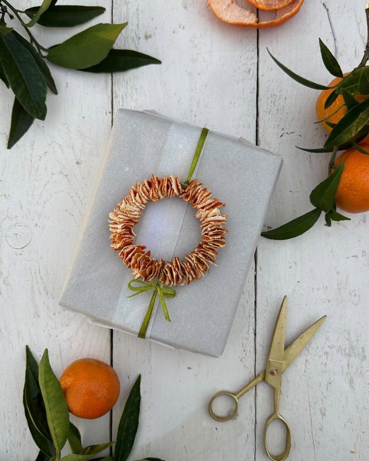 Rustic dried orange wreath gift topper from @aboutgarden with green velvet ribbon detail