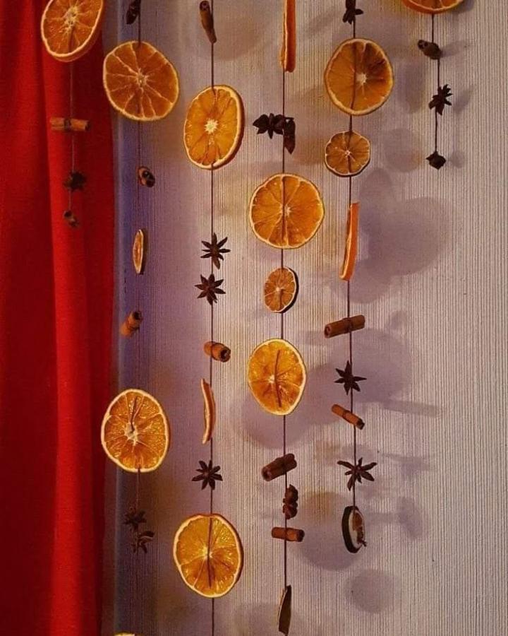 Rustic hanging garland with dried orange slices and spices from @stylkealiving.co. Aromatic wall decoration.