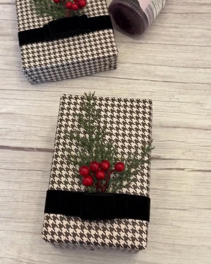Black and tan houndstooth wrapped gift from @wrappedbycarrie. Velvet ribbon with cedar and berries.