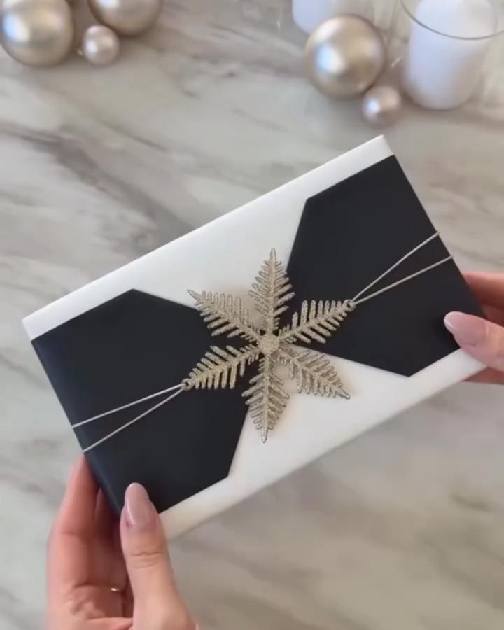 White gift box with black ribbon and gold fern decoration from @gorgeous_houses_. Modern monochrome wrapping style.